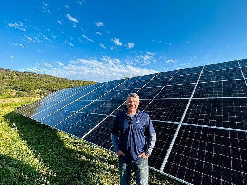 Example: Detail Solar team member in front of a ground-mount solar array