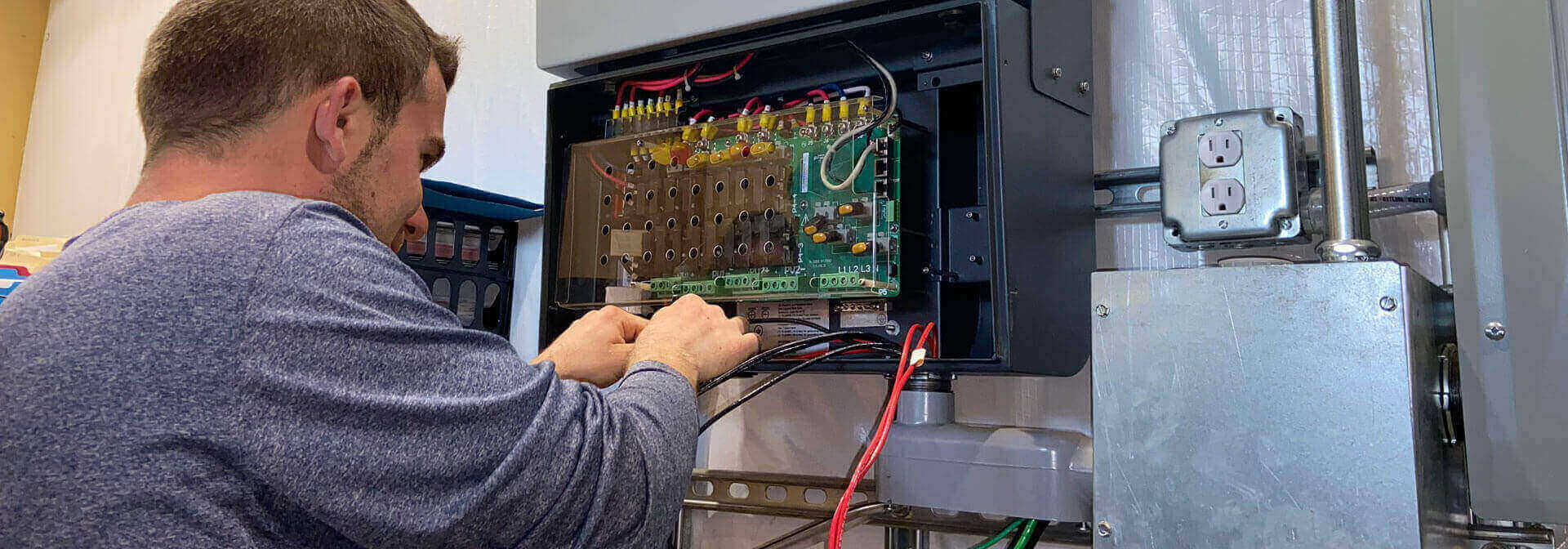 Detail Solar technician repairing wiring on solar electrical equipment