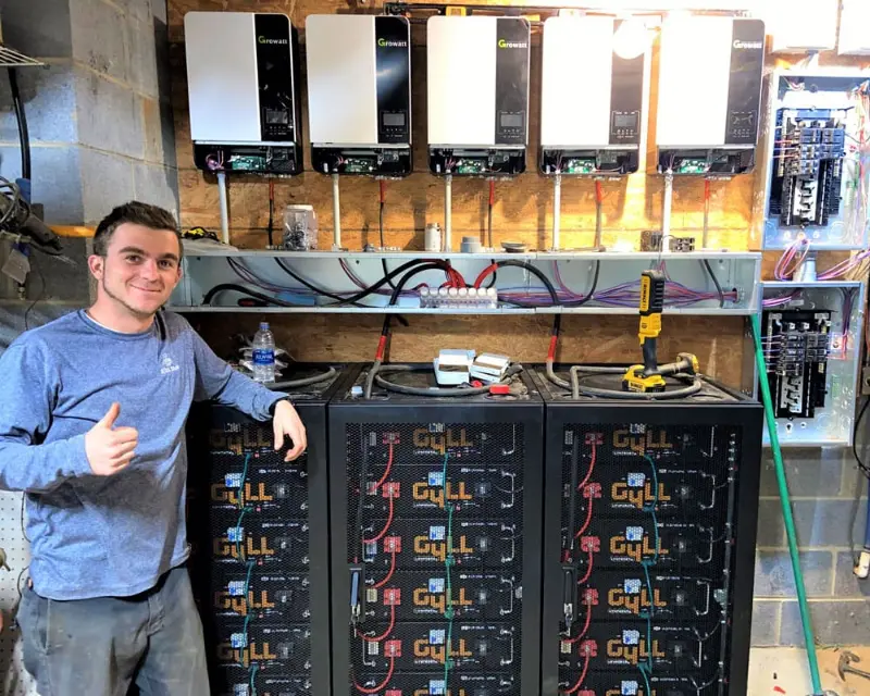 Detail Solar technician beside a battery and inverter install