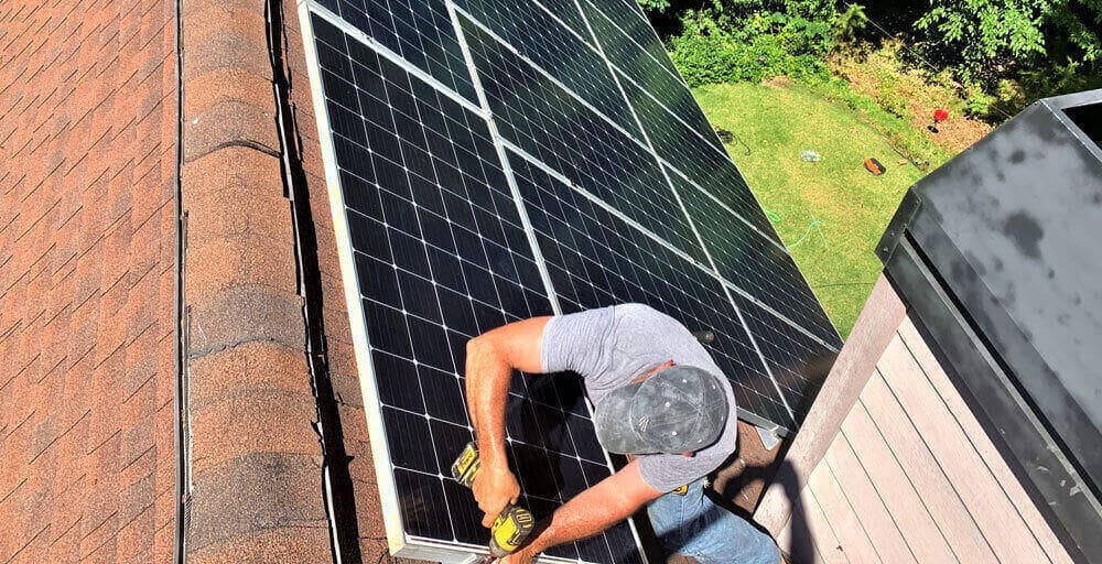 Detail Solar technician fastening a solar panel on a roof